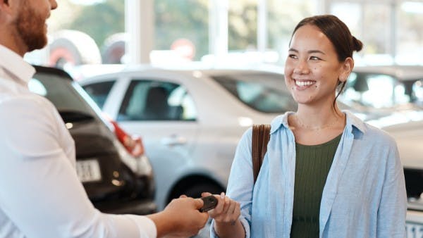 Woman buying a car at a dealership.